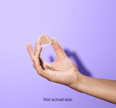 A hand holding the Gwyn Lo birth control patch